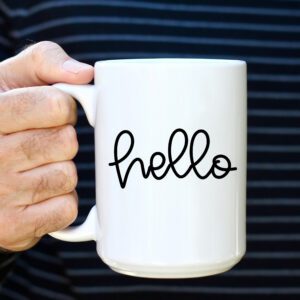 A person holding a coffee mug that says hello.