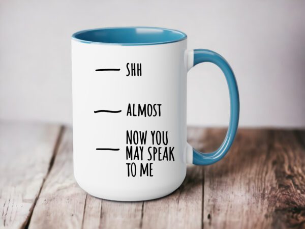 A coffee mug with the words shh almost and now you may speak to me.