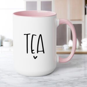 A pink coffee mug with the word tea written in black.