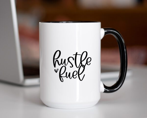 A coffee mug that says hustle fuel on it.