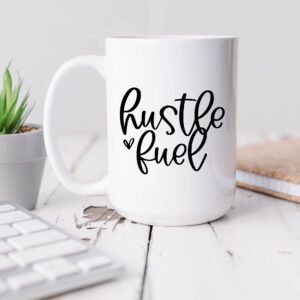 A coffee mug that says hustle fuel on it.