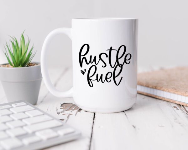 A coffee mug that says hustle fuel on it.