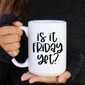 A person holding a coffee mug that says " is it friday yet ?"