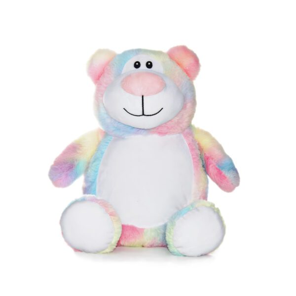 A stuffed bear with many colors is sitting on the floor.