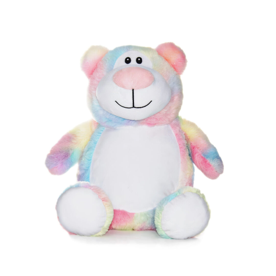 A stuffed bear with many colors is sitting on the floor.