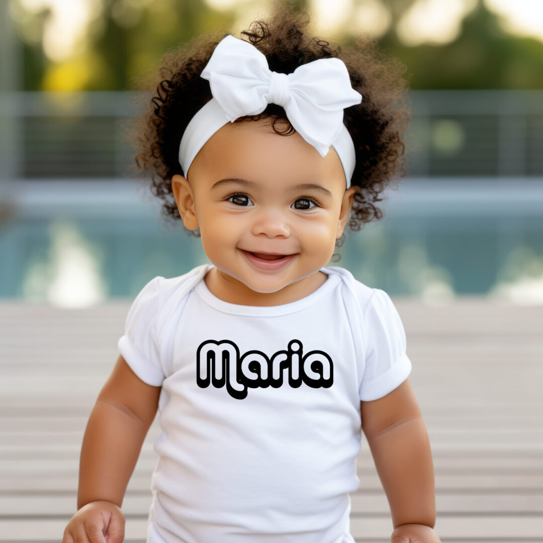 A baby girl wearing a white shirt and headband.