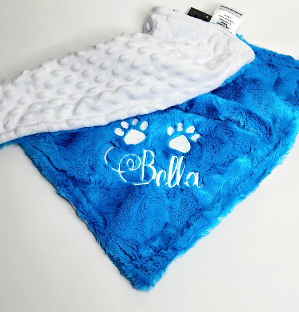 A blue and white blanket with the name bella on it