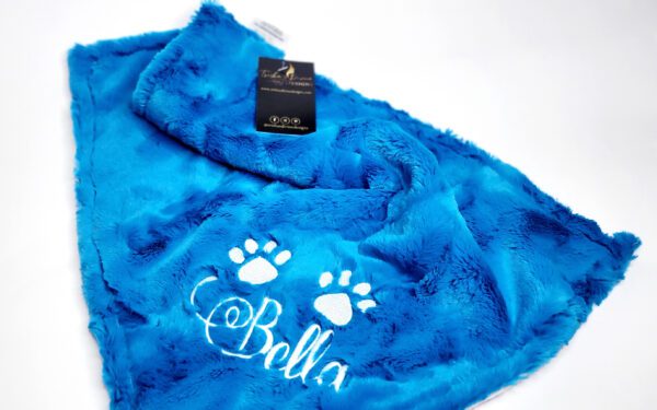 A blue blanket with the name bella written on it.