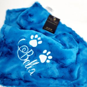 A blue blanket with white lettering and paw prints.