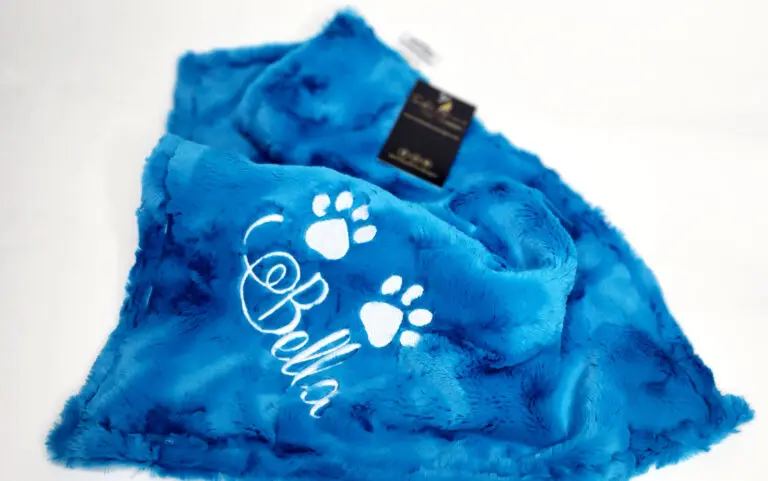 A blue blanket with white lettering and paw prints.