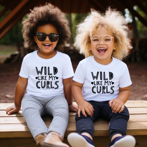 Two children sitting on a bench with wild hair.