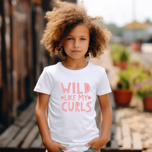 A young girl with curly hair stands on the street.