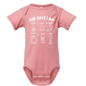 A pink onesie with the words god says i am written in white.