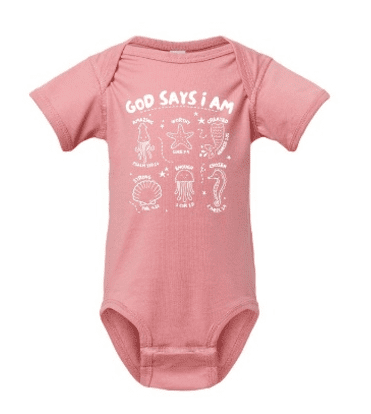 A pink onesie with the words god says i am written in white.