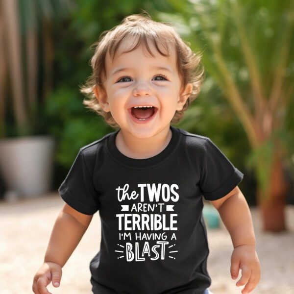 A toddler is laughing and wearing a black shirt.