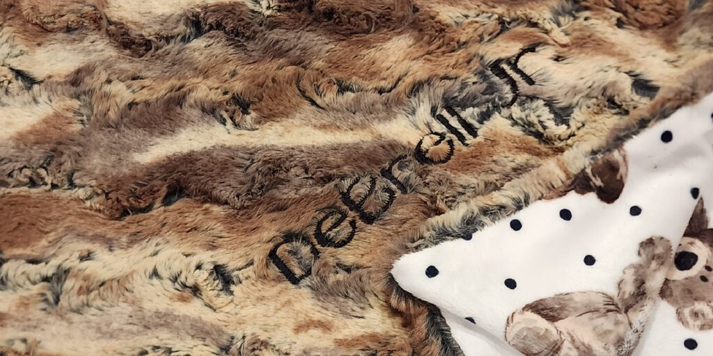 Baby Minky Blanket that has teddy bears on one side and a neutral color faux fur on the opposite side.